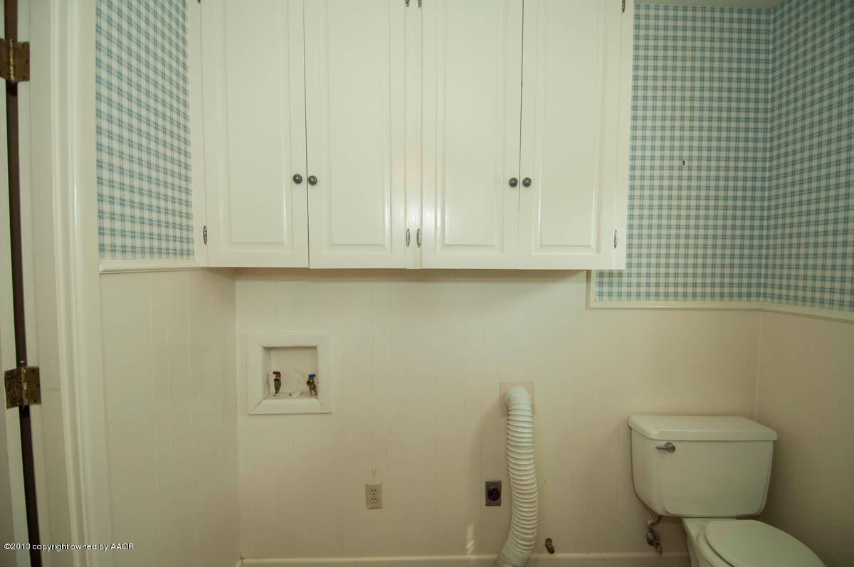 6206 Calumet Road Amarillo, TX 79106 - Photo 31 of 47 a bathroom with a toilet a sink and mirror