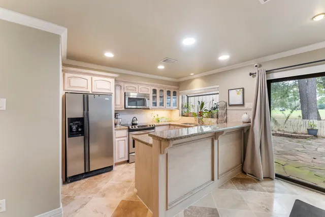 a kitchen with stainless steel appliances granite countertop a refrigerator and a stove top oven
