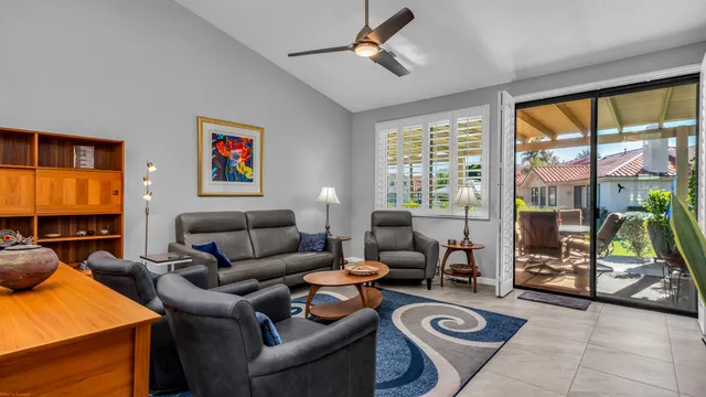 a living room with furniture a flat screen tv and a floor to ceiling window