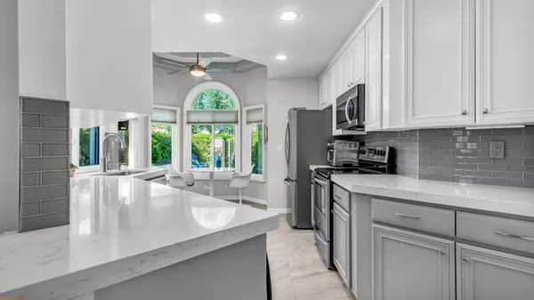 a kitchen with kitchen island granite countertop a sink a counter space appliances and cabinets