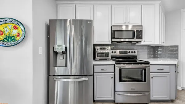 a kitchen with stainless steel appliances a refrigerator stove and microwave
