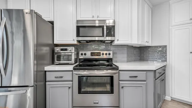 a kitchen with stainless steel appliances granite countertop a stove a refrigerator and a microwave