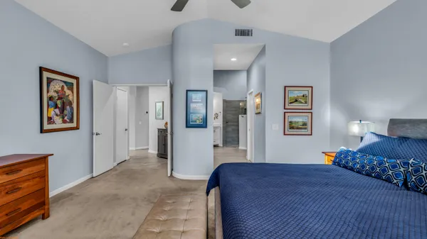 a bedroom with a bed and painting on the wall