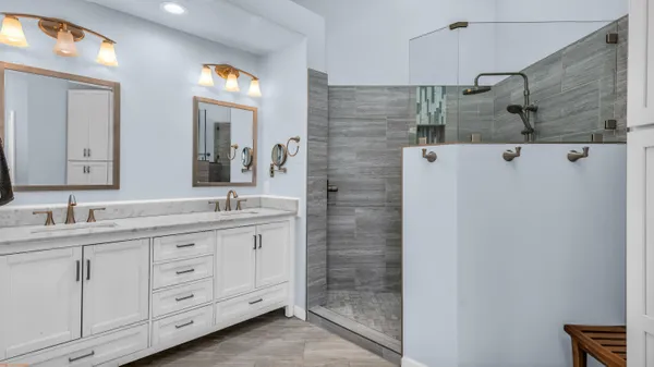 a bathroom with a double vanity sink mirror and shower