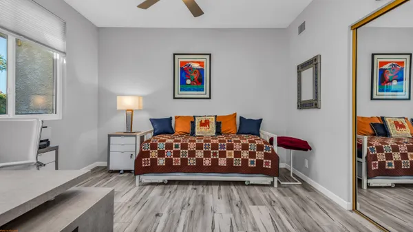 a bedroom with a bed and wooden floor