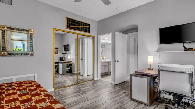 a bedroom with wooden floor closet and a window