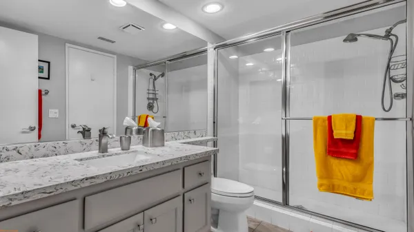 a bathroom with a granite countertop sink a toilet and shower