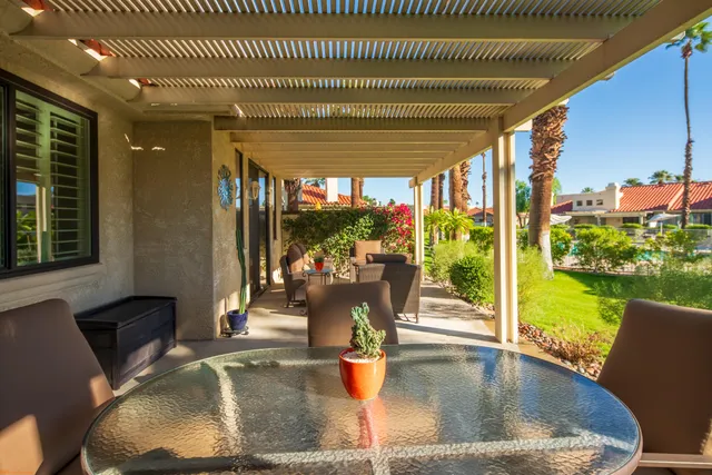 a view of swimming pool with dining table and chairs