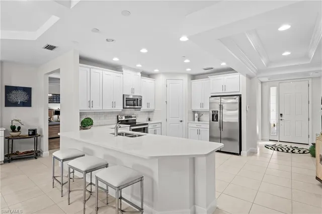 a kitchen with stainless steel appliances kitchen island granite countertop a refrigerator and a stove top oven