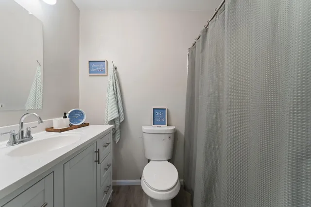 a bathroom with a toilet a sink and mirror