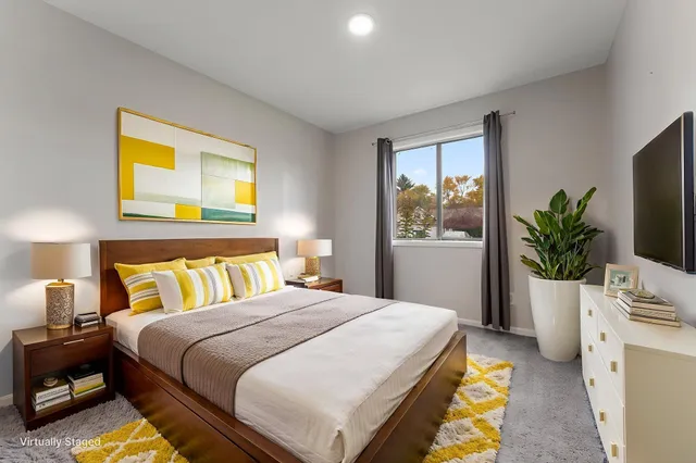 a bedroom with a bed and a potted plant