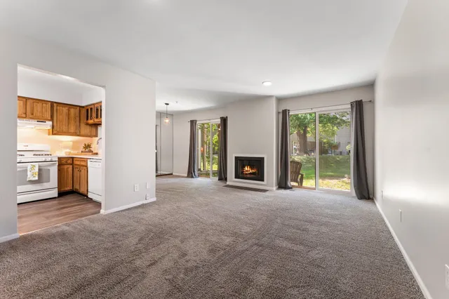 a view of an empty room with a fireplace and a window