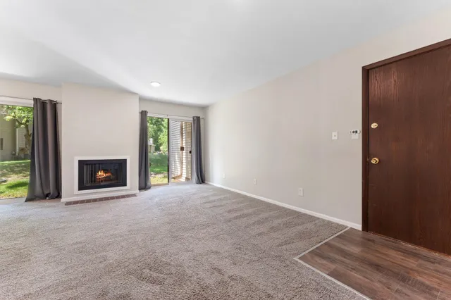 a view of an empty room with a window and fireplace