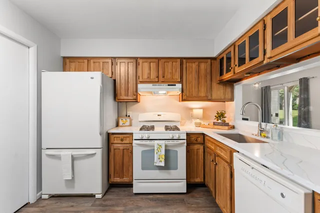 a kitchen with a stove top oven a sink and white cabinets