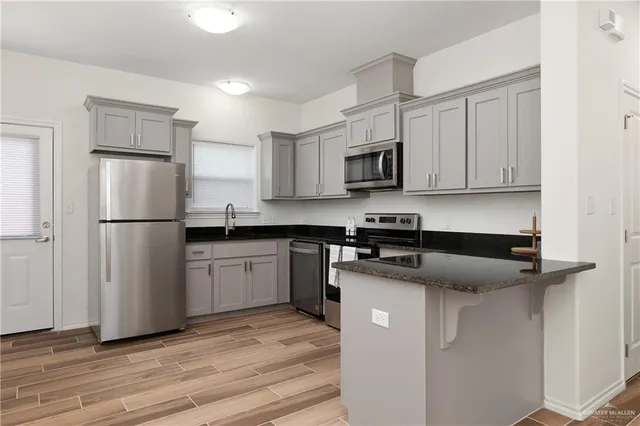 a kitchen with stainless steel appliances granite countertop a stove a sink and white cabinets