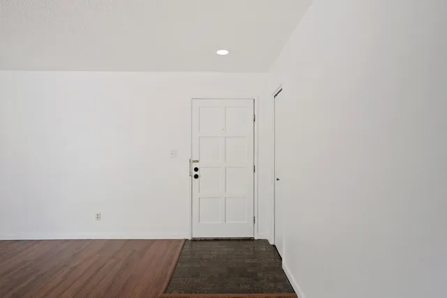 a view of wooden floor fire place and windows in a room