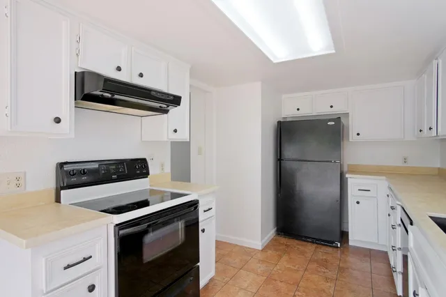 a kitchen with a sink a refrigerator and cabinets