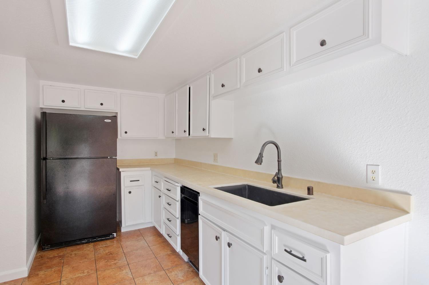 3701 Colonial Drive, Unit 156 Modesto, CA 95356 - Photo 18 of 32 a kitchen with a sink a refrigerator and cabinets
