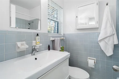 a bathroom with a sink a toilet and mirror