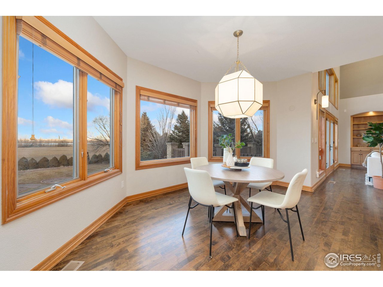 7930 Eagle Ranch Road Fort Collins, CO 80528 - Photo 11 of 40 a dining room with wooden floor a chandelier a wooden table and chairs