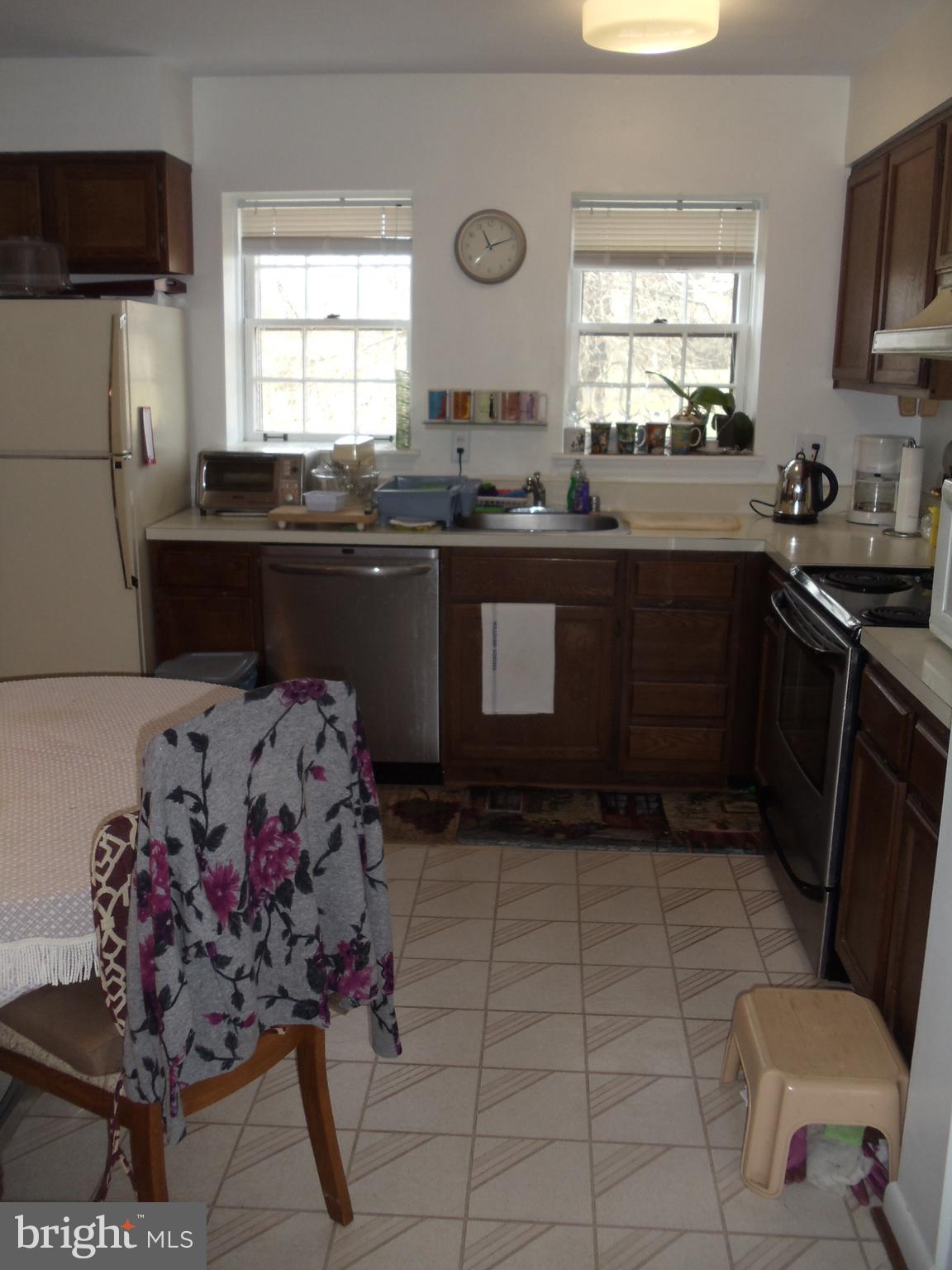 2186 Golf Course Drive Reston, VA 20191 - Photo 10 of 30 a kitchen with stainless steel appliances a sink a stove a microwave a counter top space and cabinets