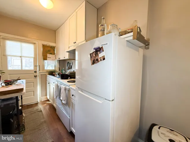 a kitchen with white cabinets and white appliances