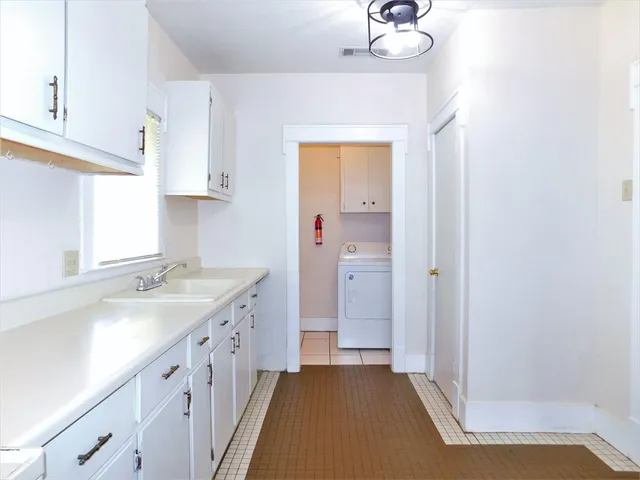 an empty room with wooden floor closet and windows