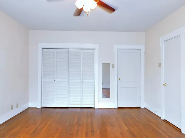 a view of a room with wooden floor and a window