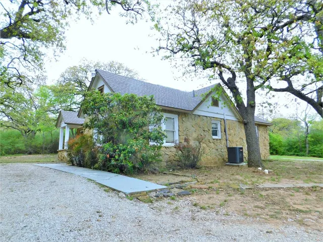 a view of a house with a tree in front of it