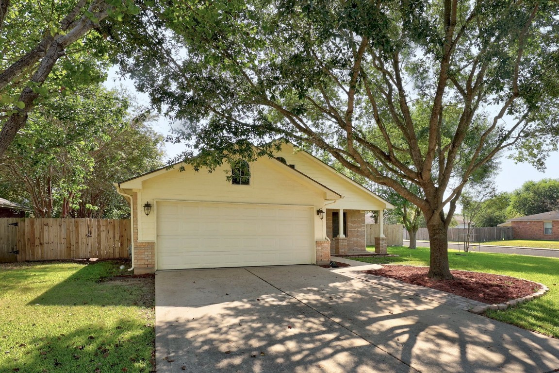 301 Nicole Way Bastrop, TX 78602 - Photo 3 of 23 a view of a yard in front of a house with a large tree
