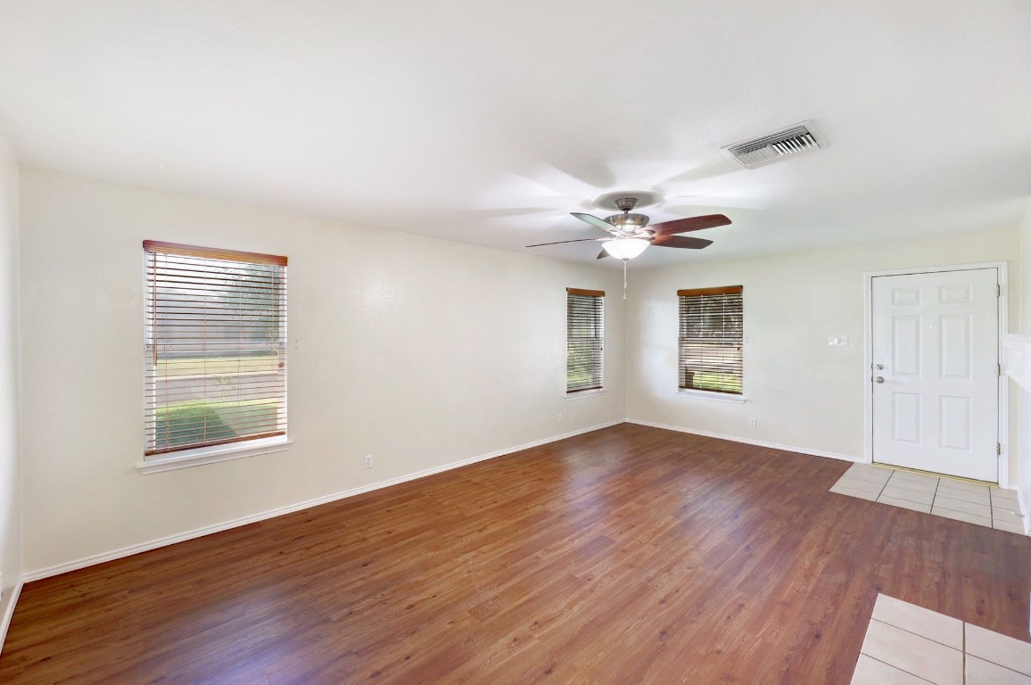 301 Nicole Way Bastrop, TX 78602 - Photo 6 of 23 an empty room with wooden floor chandelier fan and windows