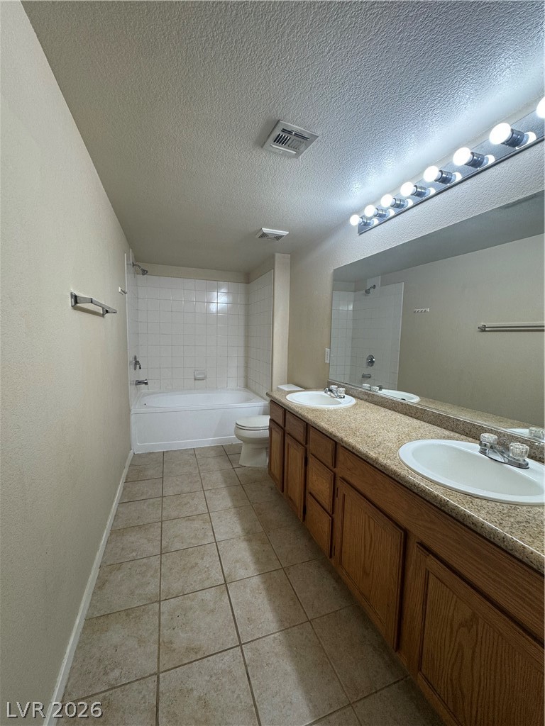 7255 West Sunset Road, Unit 2081 Las Vegas, NV 89113 - Photo 11 of 20 Bathroom with double vanity, washtub / shower combination, a textured ceiling, and light tile patterned floors