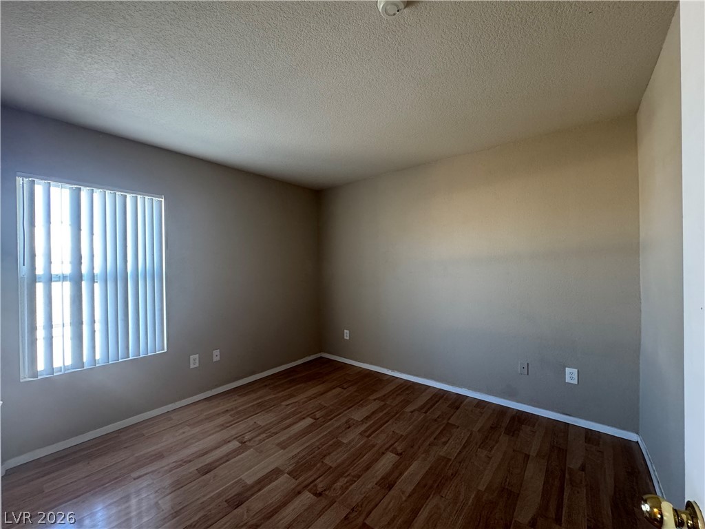 7255 West Sunset Road, Unit 2081 Las Vegas, NV 89113 - Photo 17 of 20 Spare room with dark wood-style floors and a textured ceiling