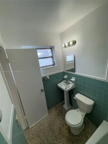 a bathroom with a toilet sink and mirror