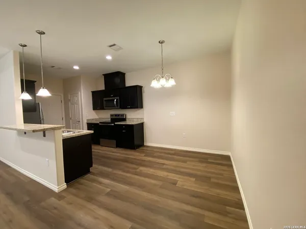 a kitchen with a sink and a flat screen tv