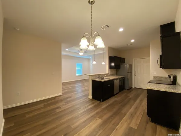 a kitchen with stainless steel appliances granite countertop a sink a stove and a refrigerator