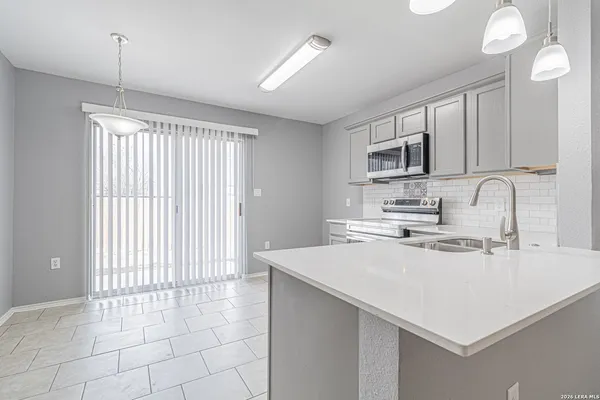 a kitchen with a sink a stove and cabinets
