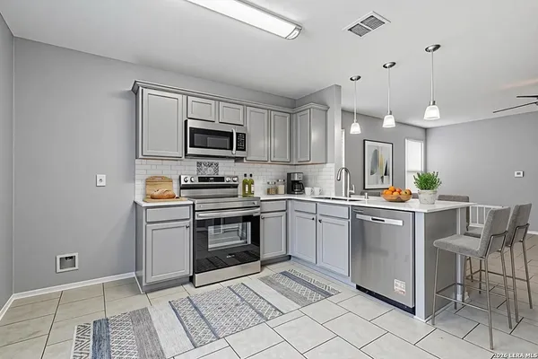 a kitchen with granite countertop a sink and appliances