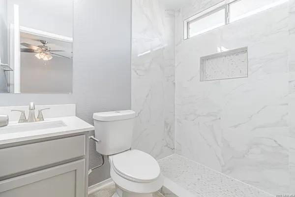 a white toilet sitting next to a bathroom sink