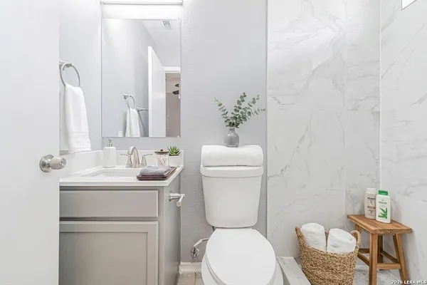 a bathroom with a toilet a sink and a mirror