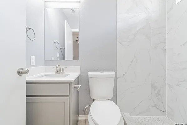 a bathroom with a toilet sink and mirror