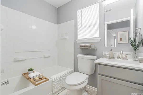 a bathroom with a granite countertop toilet a sink and a mirror