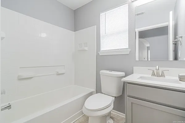 a bathroom with a sink toilet vanity and tub