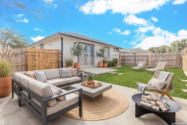 a view of a patio with couches potted plants and a big yard