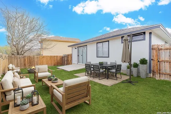 a view of a patio with couches table and chairs and garden