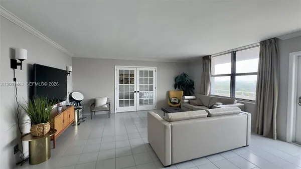 a living room with furniture a flat screen tv and a window