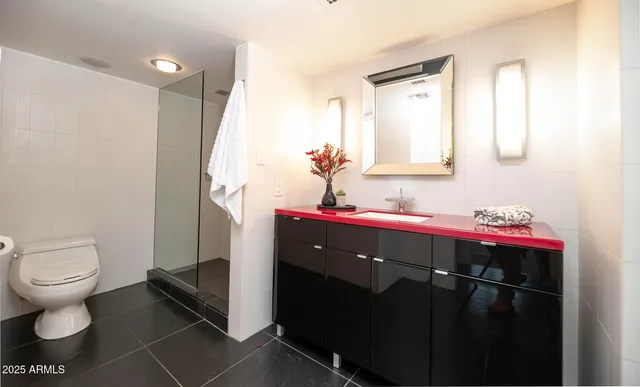a bathroom with a granite countertop sink mirror and toilet