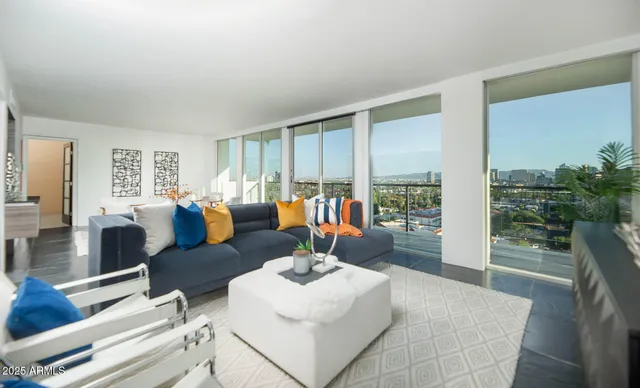 a living room with furniture a flat screen tv and a large window
