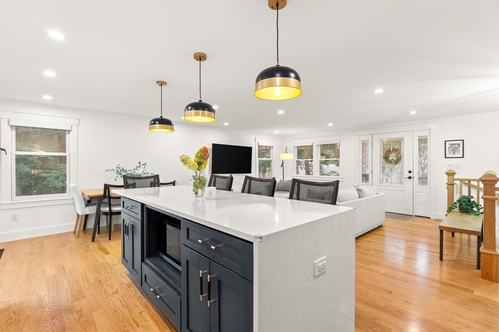 43 Oregon Road Ashland, MA 01721 - Photo 11 of 41 a large kitchen with kitchen island a dining table chairs and a wooden floor
