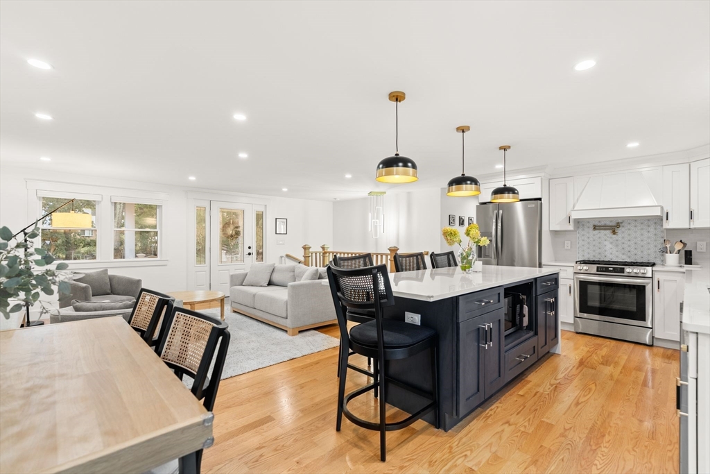 43 Oregon Road Ashland, MA 01721 - Photo 12 of 41 a kitchen with stainless steel appliances a stove a sink a kitchen island with chairs and wooden floor